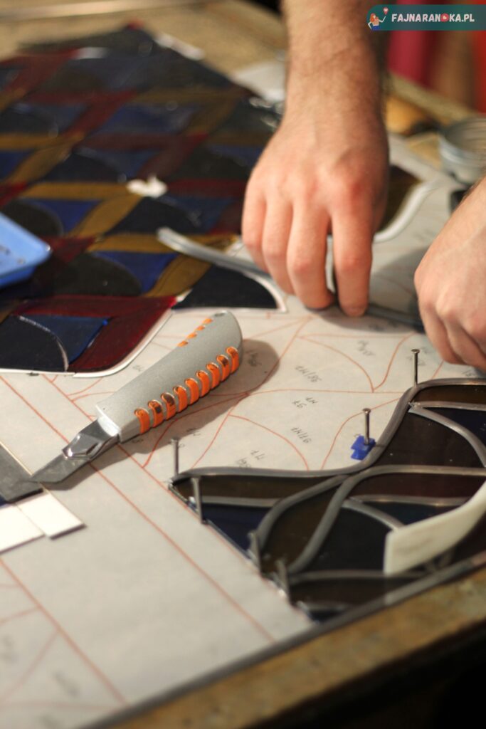 Pasowanie elementów witrażu w Muzeum i Pracowni Witrażu w Krakowie.